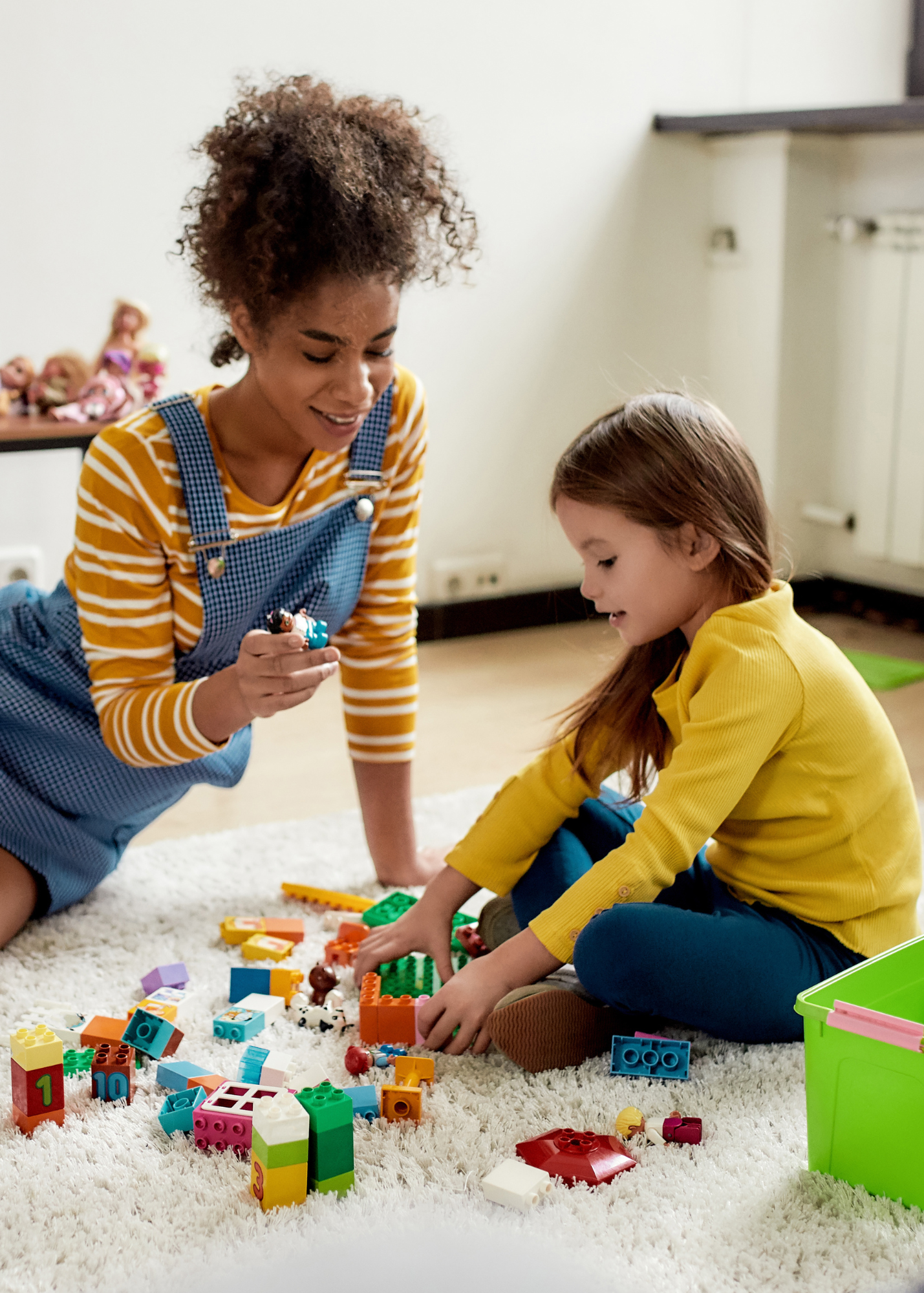 Nanny playing blocks with girl